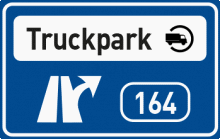 Dopravní značka „Truckpark“ Informuje na dálnici a silnici pro motorová vozidla o nejbližší křižovatce, v jejíž blízkosti se nachází komplexní obslužné zařízení pro nákladní vozidla. TestImage